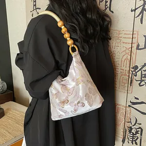 Elegant satin underarm bag with butterfly embroidery and unique wooden bead handle