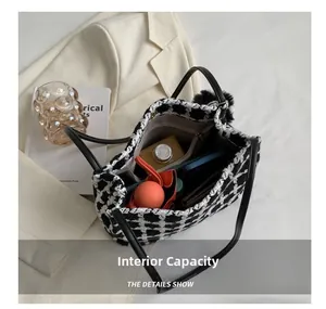 Internal capacity of black and white tweed bucket bag with zip pocket and daily essentials