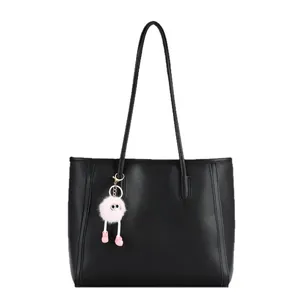 Minimalist black leather tote bag with a playful pink plush doll pendant for women