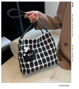 Detailed view of checkered tote bag with woven texture and plush doll charm