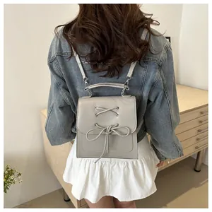 Nahaufnahme des grauen Lederrucksacks mit Schleife auf dem Rücken des Models