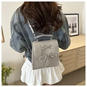 Detail eines grauen Mode-Rucksacks mit Schleifen-Element, getragen von einem Model