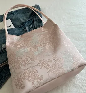 Close-up of pink jacquard handbag featuring traditional Chinese landscape embroidery