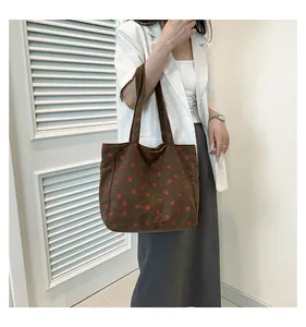 Détail du sac cabas en velours côtelé avec motifs fraises rouges sur fond marron foncé