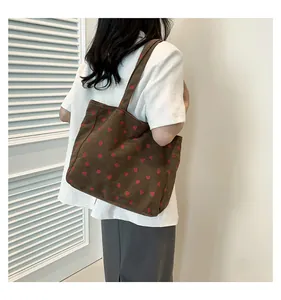 Gros plan détaillé d'un sac cabas en velours côtelé marron avec imprimés fraises