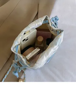 Vue de dessus montrant l'intérieur spacieux du sac seau bleu clair avec des objets usuels