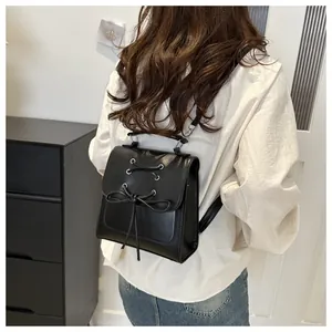 Detail eines schwarzen Leder-Minirucksacks mit Schleife auf einem weiblichen Modell
