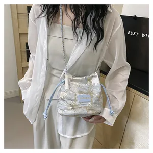 Détail du sac seau en jacquard bleu et argent avec cordon et finitions en cuir souple