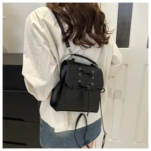 Model-Ansicht eines schicken schwarzen Mini-Rucksacks mit Schnürung, Schleife und Gurten