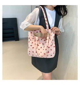 Vue détaillée du sac cabas en velours côtelé rose avec imprimés fraises et texture