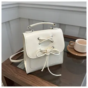 Nahaufnahme der cremefarbenen PU-Lederhandtasche mit dekorativem Schleifen-Detail