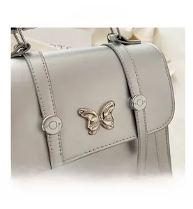 Close-up of shiny silver pearl texture bag with butterfly metal ornament and studs