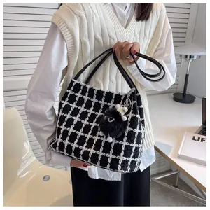 Classic black and white checkered tweed tote bag with plush pom-pom charm and slim handles