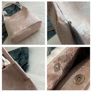Detailed macro view of pink floral jacquard fabric with gray tassel and metal magnet clasp