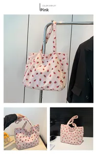 Détail du sac fourre-tout en velours rose avec imprimé fraise et texture côtelée douce