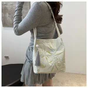 Detailed close-up of jacquard canvas bag with bamboo pattern and tassel accessory