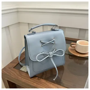 Detailansicht der hellblauen PU-Lederhandtasche mit Schleife und Metallösen