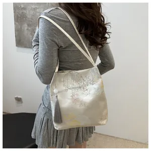 Close-up of jacquard canvas bag featuring embroidery patterns and grey tassel decor