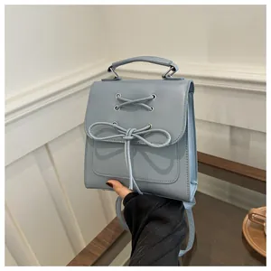 Detail eines hellblauen Mini-Rucksacks mit Schleife und Tragegriff in Lifestyle-Umgebung