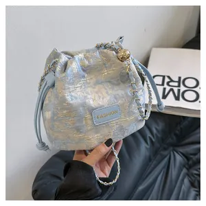 Détail du sac seau jacquard bleu clair avec bandoulière chaîne dorée et étiquette FASHION