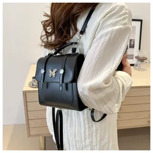 Close-up of black leather backpack with vintage silver butterfly clasp and metal studs