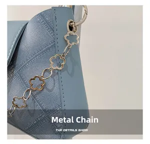 Detail showing light blue woven bag with decorative flower shaped hardware chain