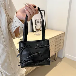 Black leather mini tote bag with five decorative bows and thin top handles