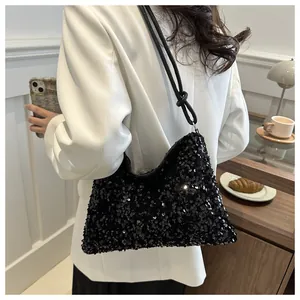 Detalle de bolso de lentejuelas negras con correa anudada sobre blazer blanco