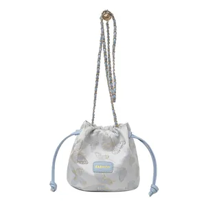 Sac seau blanc élégant avec broderie papillon bleu clair et bandoulière en chaîne