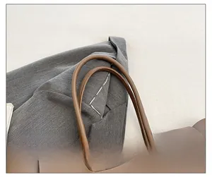 Close-up of the comfortable round leather handles on this large vintage taupe tote bag