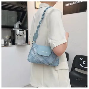 Detail of light blue shoulder bag featuring woven strap and silver flower chain link