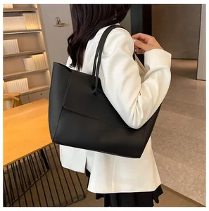 Detail of a large black tote bag with flap closure and double shoulder straps for work