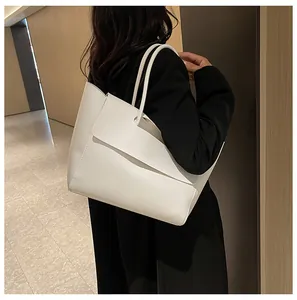 Detailed side view of a minimalist white tote bag with long straps on a female model