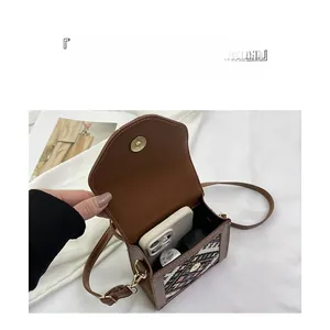 Detailed interior of vintage brown leather crossbody bag with ethnic weaving and pockets