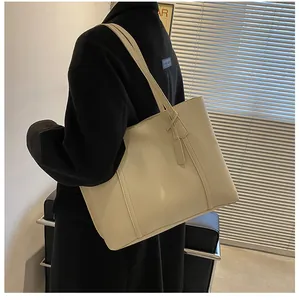 Detail van een grote crèmekleurige leren shopper met elegante verticale stiksels