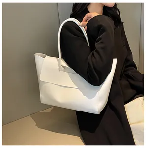 Minimalist white tote bag showing spacious design and matte finish on a model side-view
