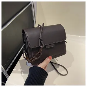Dettaglio borsa a tracolla marrone caffè con texture opaca e catena in resina