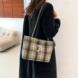 Retro plaid tote bag with deer pendant and gold chain strap shown on a model