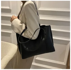 Detailopname van de minimalistische zwarte zachte lederen tote bag met grote opslagruimte