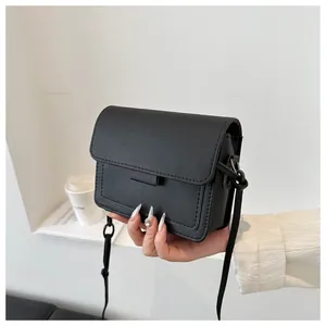 Dettaglio di una borsa a tracolla nera in pelle con cuciture e design a patta