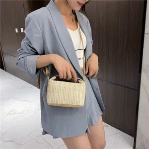 Elegante bolso bandolera de paja tejida beige con correas de cuero marrón de verano