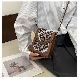Detailed view of an ethnic woven crossbody phone bag with colorful geometric patterns