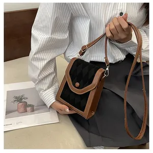 Detail of vintage brown leather contrast phone bag with quilted texture and metal button