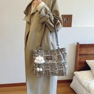 Canvas tote bag with black and white geometric patterns and brown leather handles