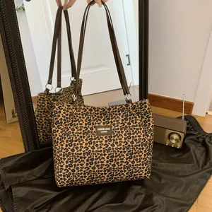 Chic leopard print bucket tote bag with leather straps and silver hardware detail