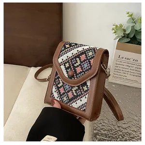 Close-up of retro ethnic crossbody phone bag with colorful geometric woven pattern