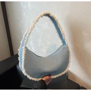 Detail of light blue denim hobo bag with white faux fur trim and silver zipper closure