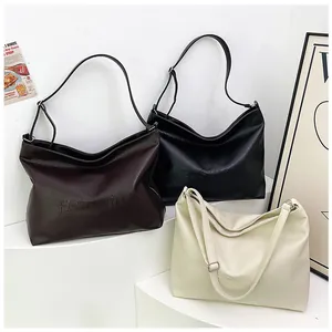 Litchi texture tote bag detail showing black, brown and white leather options