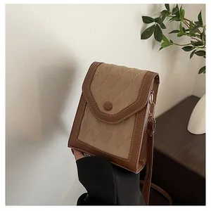 Detail view of a vintage brown quilted crossbody phone bag with plush fabric finish