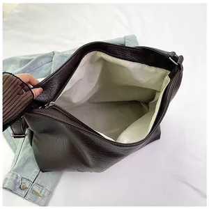 Close-up of soft leather tote bag showing spacious interior and grainy texture